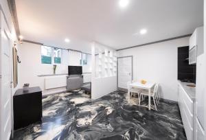 维尔纽斯Klaipedos Apartment - Lollo Luxury的厨房配有白色橱柜和黑色大理石地板