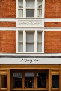 伦敦Magda Boutique Rooms的砖砌建筑的外墙,上面有标志