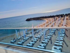 奥林普Meduza Hotel的享有带椅子和遮阳伞的海滩美景