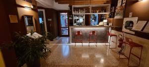 梅斯特UNAWAY Ecohotel Villa Costanza Venezia的一间酒吧,在房间里有两个红色凳子