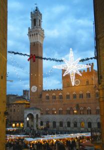 锡耶纳I Terzi Di Siena - Rooms Only的一座带钟楼的大型建筑,拥有圣诞星