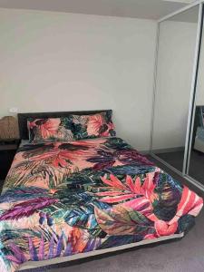 墨尔本Stylish , CBD , Views的卧室内一张带五颜六色棉被的床
