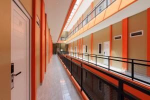 HajimanaRedDoorz near GSG UNILA Lampung的一座建筑中空无一人的走廊,有橙色的墙壁