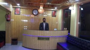 斯利那加Hotel Star of Kashmir的站在讲台后面,在一间有钟的房间