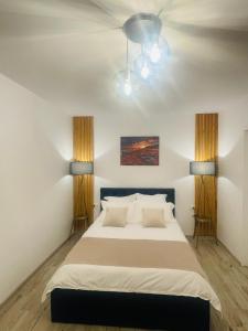 瓦特拉多尔内Apartament CHIC的一间卧室配有一张大床和两盏灯