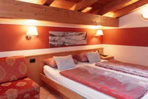 利维尼奥Hotel Garni Rin Da Rin的红色墙壁客房的两张床