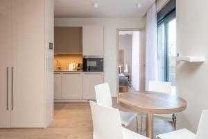 奥米什Villa Brzet - Luxury Boutique Apartments的厨房以及带木桌和白色椅子的用餐室。