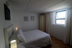 阿尼斯顿Dyers House Kassiesbaai Arniston的卧室配有白色的床和窗户。