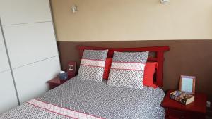 南特L'escapade的一间卧室配有红色和白色枕头的床