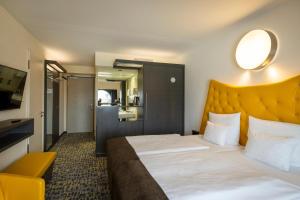 汉堡ARCOTEL Onyx Hamburg的酒店客房设有一张大床,上面有黄色床头板