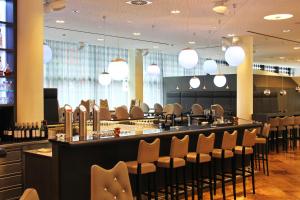 汉堡ARCOTEL Onyx Hamburg的餐厅设有配备椅子和灯的酒吧
