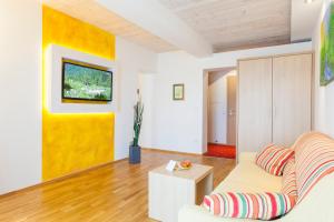 WenigzellJoglland Hotel Prettenhofer的带沙发和黄色墙壁的客厅