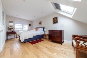 泰晤士河畔金斯顿Stylish 3 BDR apartment wfree parking and garden的一间卧室配有一张床、一个梳妆台和一扇窗户。