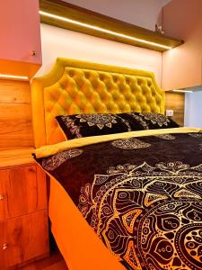 迪瓦伊巴雷Zlatni apartman Borovi的一间卧室配有一张带黄色床头板的大床