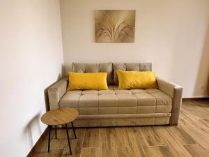 迪瓦伊巴雷Zlatni apartman Borovi的客厅里一张带两个黄色枕头的沙发