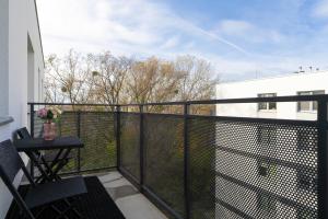 波兹南Apartment with 2 Bedrooms and FREE GARAGE Poznań by Renters的阳台设有黑色围栏和桌子。