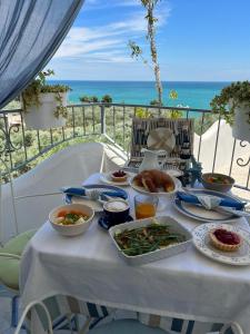 马蒂纳塔Dimora Mediterranea的一张桌子,上面有食物,后面有海洋