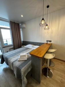 敖德萨Panorama 44的一间卧室配有一张带木桌和书桌的床。