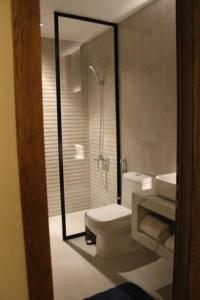 利雅德Al Muhaidb Residence Jawazat的一间带卫生间和玻璃淋浴间的浴室