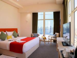利雅德Novotel Suites Riyadh Centre的酒店客房设有一张大床和一间客厅。