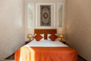 巴库Nizami Boutique by La Casa的一间卧室配有一张带橙色毯子和两盏灯的床。
