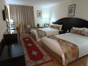 非斯皇家幻影菲斯酒店的酒店客房,设有两张床和一张沙发