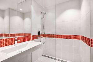 克拉科夫Vienna House Easy by Wyndham Cracow的带淋浴和盥洗盆的白色浴室