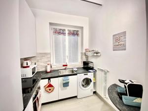 布斯托阿西齐奥Irene House Malpensa Milan Lakes的小厨房配有洗衣机和水槽