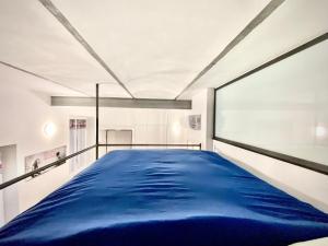 布斯托阿西齐奥Irene House Malpensa Milan Lakes的一张大床,位于带大窗户的房间里
