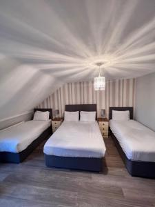 比利克费德斯通酒吧和住宿加早餐旅馆的一间卧室配有两张床和吊灯。