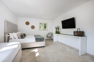 皮雅诺迪索伦托Sopramare Resort的一间白色卧室,配有床和电视