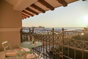 诺维格勒伊斯特拉Palazzo Rainis Hotel & Spa - Small Luxury Hotel - Adults Only的阳台配有桌椅,享有海景。