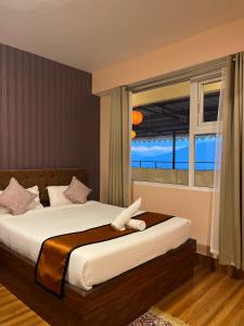 甘托克Little Sikkim Inn的一间卧室设有一张床和一个海景窗户