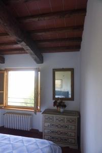 塞拉瓦莱皮斯托耶塞Casa Tre Pini的一间卧室配有床、镜子和梳妆台