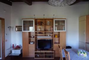塞拉瓦莱皮斯托耶塞Casa Tre Pini的客厅配有电视和桌椅