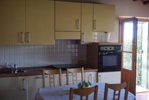 塞拉瓦莱皮斯托耶塞Casa Tre Pini的厨房配有桌椅和水槽。