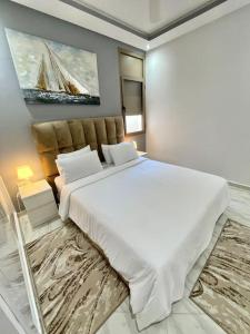 特马拉A2 Appartement entièrement neuf au cœur de Témara的卧室配有一张白色大床和一幅画