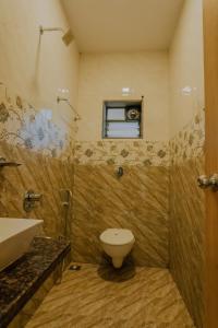 马哈巴莱斯赫瓦尔oakwood mahabaleshwar的一间带卫生间、水槽和窗户的浴室