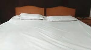 Hotel YOGIRAJ LODGING BOARDIING,Deulgaon Raja的一张白色的床,上面有两个白色的枕头
