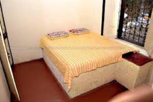 Hotel YOGIRAJ LODGING BOARDIING,Deulgaon Raja的一个小房间,窗户前设有一张床