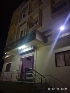 Hotel YOGIRAJ LODGING BOARDIING,Deulgaon Raja的一座带紫色门和阳台的建筑