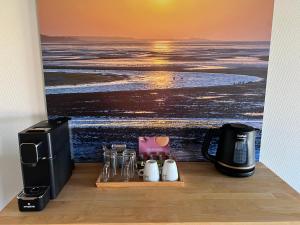 东弗利兰Hotel Posthuys Vlieland的一间配备有咖啡壶的客房,享有海洋美景。