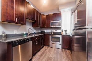 匹兹堡Massive Home - GroupStay - Parking & Location的厨房配有木制橱柜和不锈钢用具