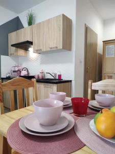 库多瓦-兹德鲁伊Apartamenty & Pokoje pod Gruszą的厨房配有带碗和盘子的桌子