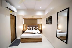 孟买HOTEL ALFA EXECUTIVE的一间卧室配有两张床和镜子