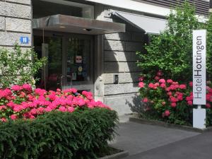 苏黎世霍廷根酒店 _x000D_的粉红色花卉建筑前的标志