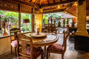 MontongbuwohLombok Stanley Garden Villas的一间带桌椅和大窗户的用餐室