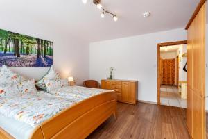 迈内尔茨哈根Ferienwohnung Busch的一间卧室配有一张床、梳妆台和镜子