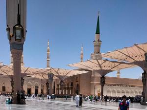麦地那Roya Al Andalus Hotel的一座有清真寺的大建筑,高塔