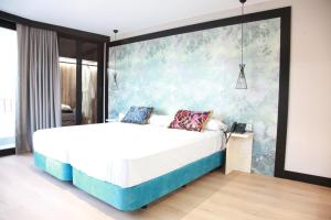 塞雷纳新镇Hotel Suites Moma Centro的一间卧室配有一张带大墙的床